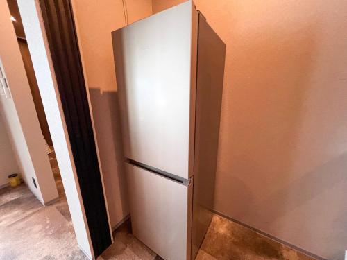 a stainless steel refrigerator in the corner of a room at LIFEMENT GLANZ Okimi in Etajima