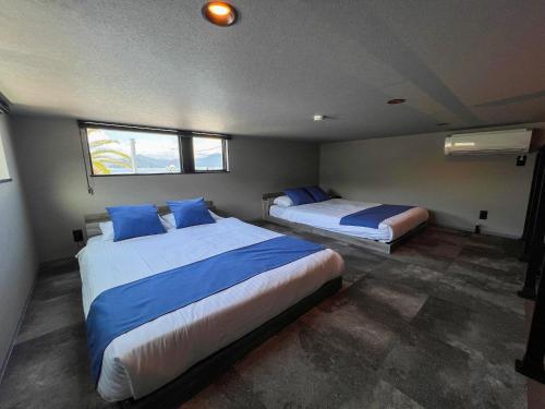 a bedroom with two beds and a window at LIFEMENT GLANZ Okimi in Etajima