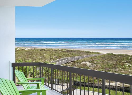 a balcony with two chairs and the beach at Margaritaville Beach Resort South Padre Island in South Padre Island