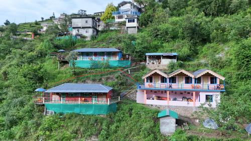 a group of houses on the side of a hill at The Mud house, Mussoorie in Mussoorie