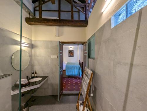 Un baño con lavabo y una cama en una habitación. en Shruti by Luxunlock Private Villas, en Nannilam