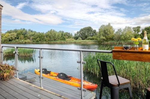 a boat sitting on a dock on a lake at Mayflower lakeside hot tub in South Cerney