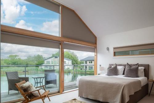a bedroom with a bed and a large window at Mayflower lakeside hot tub in South Cerney