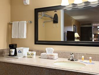 a bathroom counter with a sink and a mirror at Days Inn by Wyndham Henryetta in Henryetta