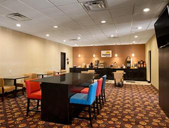a restaurant with a table and chairs and a bar at Days Inn by Wyndham Henryetta in Henryetta
