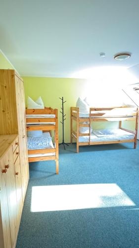 a room with two bunk beds in a room at Pension auf dem Pferdehof Gut Greppin - mit WLAN, Sitzecke, Garten & kostenlosem Parken in Greppin