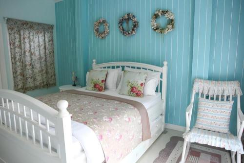 a bedroom with a white bed and a blue wall at Baan Hmon-Oon in Chiang Mai