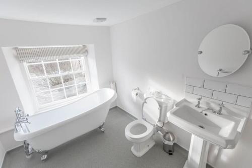 uma casa de banho com uma banheira, um WC e um lavatório. em The Crown Inn em Towcester