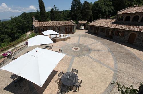 an outdoor patio with tables and white umbrellas at Agriturismo Lapone in Orvieto