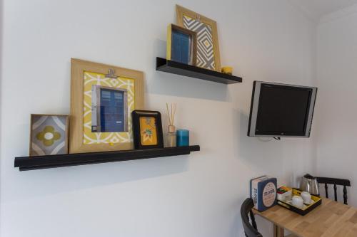 a room with a table and a tv on a wall at Casas da Formosa - Casa do Postigo in Tavira