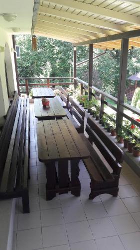 a wooden table with benches on a porch at Casa Lacului in Malaia