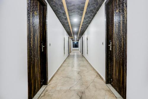 a corridor with wooden doors and a tile floor at Palette Hotel and Resort Bareilly Formerly Bellazio Suites in Bareilly