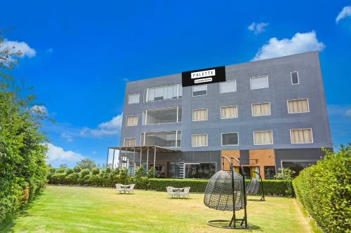 a hotel with a playground in front of a building at Palette Hotel and Resort Bareilly Formerly Bellazio Suites in Bareilly
