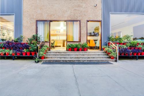 a building with stairs and flowers in red pots at Palette Hotel and Resort Bareilly Formerly Bellazio Suites in Bareilly