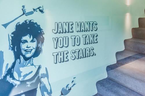 a wall with a sign that says dance wants you to take the stairs at The Dutch Maastricht in Maastricht