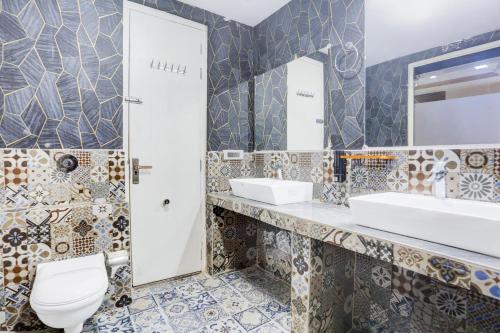 a bathroom with two sinks and a toilet at Palette Hotel and Resort Bareilly Formerly Bellazio Suites in Bareilly