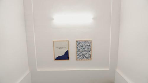 two framed photographs on a white wall in a museum exhibit at Wave in Cochin
