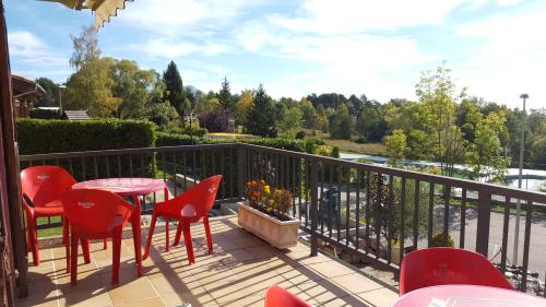 a patio with red chairs and a table on a balcony at Apartamentos Els Ocells in Camprodon