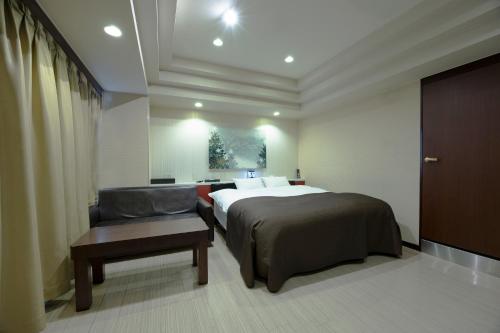 a hotel room with a bed and a chair at ホテル アン 岐阜-大人専用 in Gifu
