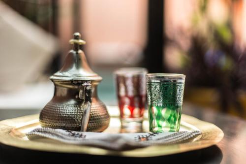 een dienblad met twee glazen en een theepot op een tafel bij Villa Amira & Spa in Marrakesh