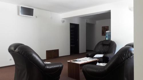 two black leather chairs and a table in a living room at Casa Lacului in Malaia