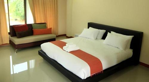 a bedroom with a large bed and a couch at So Herbs at Home in Chiang Rai