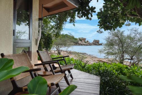 a porch with chairs and a view of the water at Kira Baya Koh Samed in Ko Samed