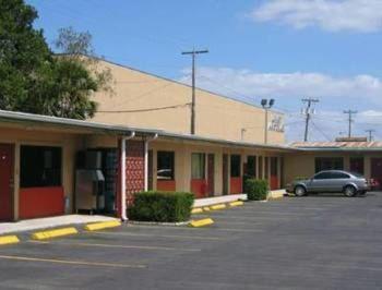 a car parked in a parking lot in front of a motel at Plaza Travel Inn in Clewiston