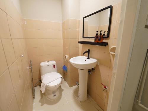 a bathroom with a toilet and a sink and a mirror at OYO 1152 Hotel Precious Garden Place in Indang
