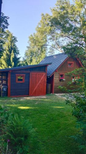 a red and blue barn with a grass yard at Ubytko ráj pod kaštanem in Jablonec nad Nisou