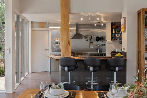 a kitchen with a bar with stools and a table at The Treehouse in Moama