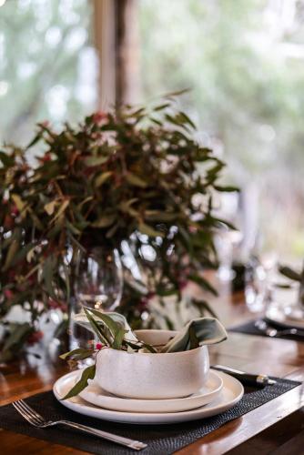 a table with a plate on a table with a plant at The Treehouse in Moama