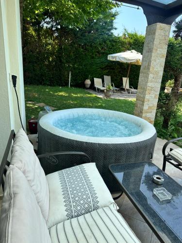 a hot tub sitting on a patio next to a table at 2K Eco Villa in Plagiárion