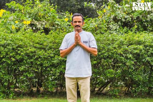 a man standing with his hands in the grass at StayVista at The Mira House with Pool, WiFi in Sohna