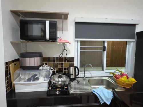 Ban Nong ChaengにあるPattiya Houseのキッチン(シンク、電子レンジ付)