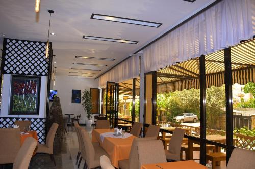 a restaurant with tables and chairs and large windows at Sun View Hotel in Addis Ababa
