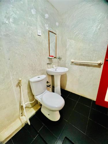 a bathroom with a toilet and a sink at The Family Beach Villa in Uswetakeiyawa