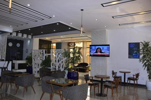a restaurant with tables and chairs and a flat screen tv at Sun View Hotel in Addis Ababa