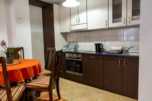 a kitchen with a table and a stove and cabinets at GRADINA - Stan na dan in Doboj