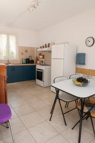 a kitchen with a table and a white refrigerator at Traditional Family House in Grizáta