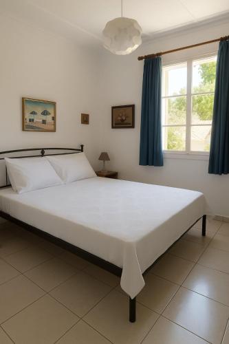 a bedroom with a large white bed with blue curtains at Traditional Family House in Grizáta