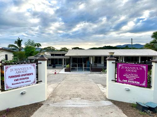 a building with two signs in front of it at Cosy Furnished Unit Great Spot Labasa Jumanzuls Abode in Labasa