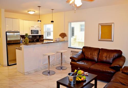 uma sala de estar com um sofá de couro e uma cozinha em Ocean Drive Villas em Hollywood