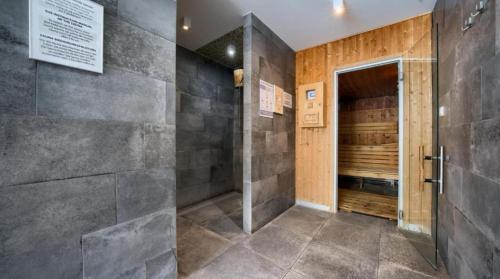 a bathroom with a walk in shower and a door at SEA & SMILE APARTMENT - BASEN, SAUNA, PARKING, WIFI, SPA Kołobrzeg Podczele in Kołobrzeg