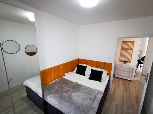 a bedroom with a bed with a wooden headboard at SEA & SMILE APARTMENT - BASEN, SAUNA, PARKING, WIFI, SPA Kołobrzeg Podczele in Kołobrzeg