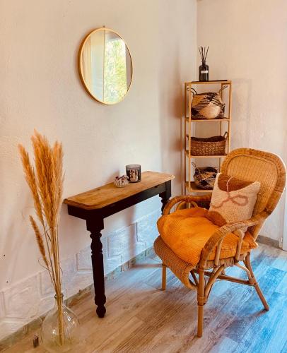 a room with a table and a chair and a mirror at Les jardins de Phidji in Buzet-sur-Tarn