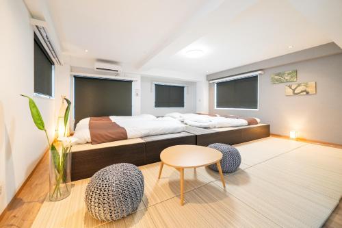 a bedroom with a bed and a table and chairs at Nestry Asakusa 502号室 in Tokyo