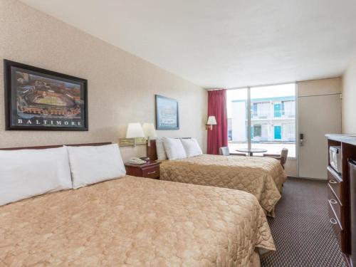 a hotel room with two beds and a window at Ramada Limited Norfolk in Norfolk