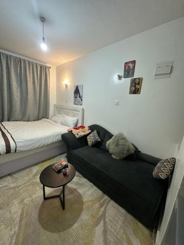 a living room with a couch and a bed at WONDERs HOME in Nairobi