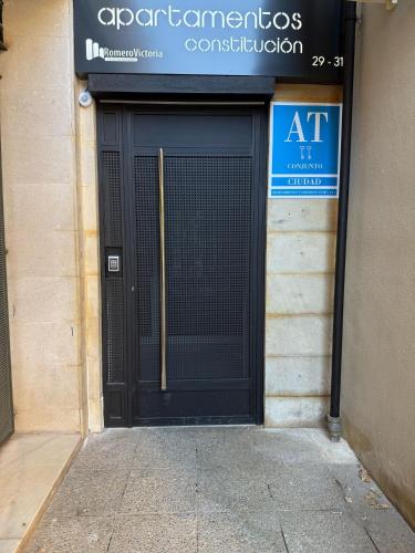 a black door to a building with a sign on it at Apartamentos Constitución in Granada
